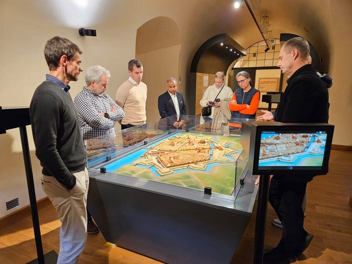 udeleženci stojijo in se ogledujejo reliefni zemlejvid