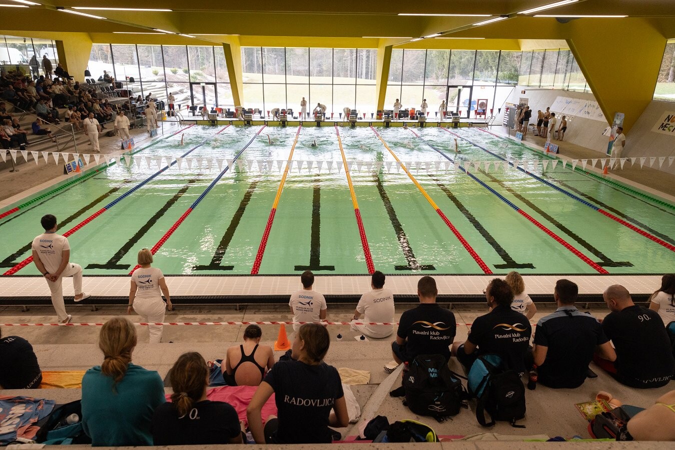 gledalci s tribun spremljajo tekmovanje plavalcev v Bazenu Novo mesto