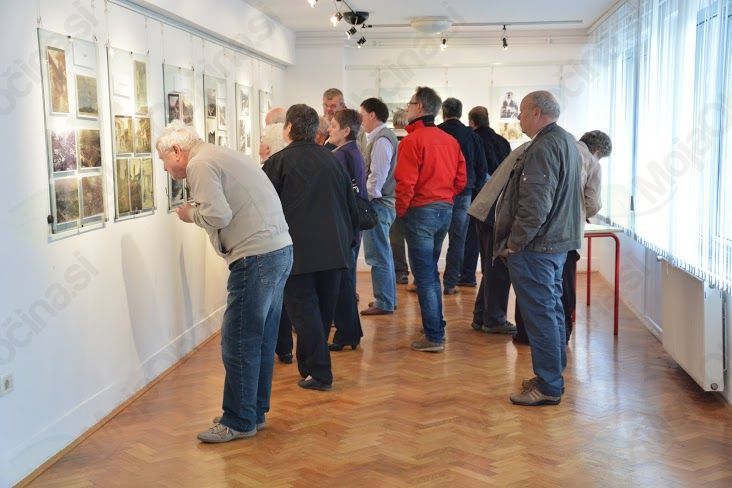 Obiskovalci razstave z zanimanjem gledajo stare fotografije (foto: Veronika Kravos)