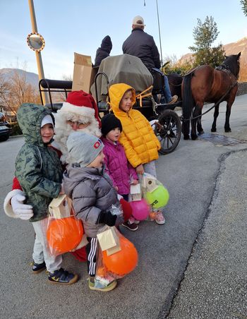 Veseli otroci v objemu Božička v Žapužah