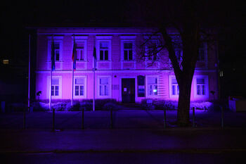 Vijolična osvetlitev občinske stavbe ob dnevu invalidov